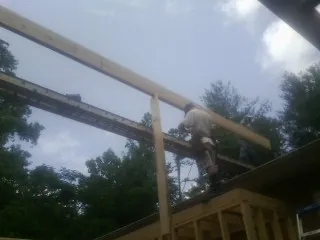 Carpenter setting a ridge beam over a new addition frame — Ice Dam Removal by Roofing Brothers in Mandan