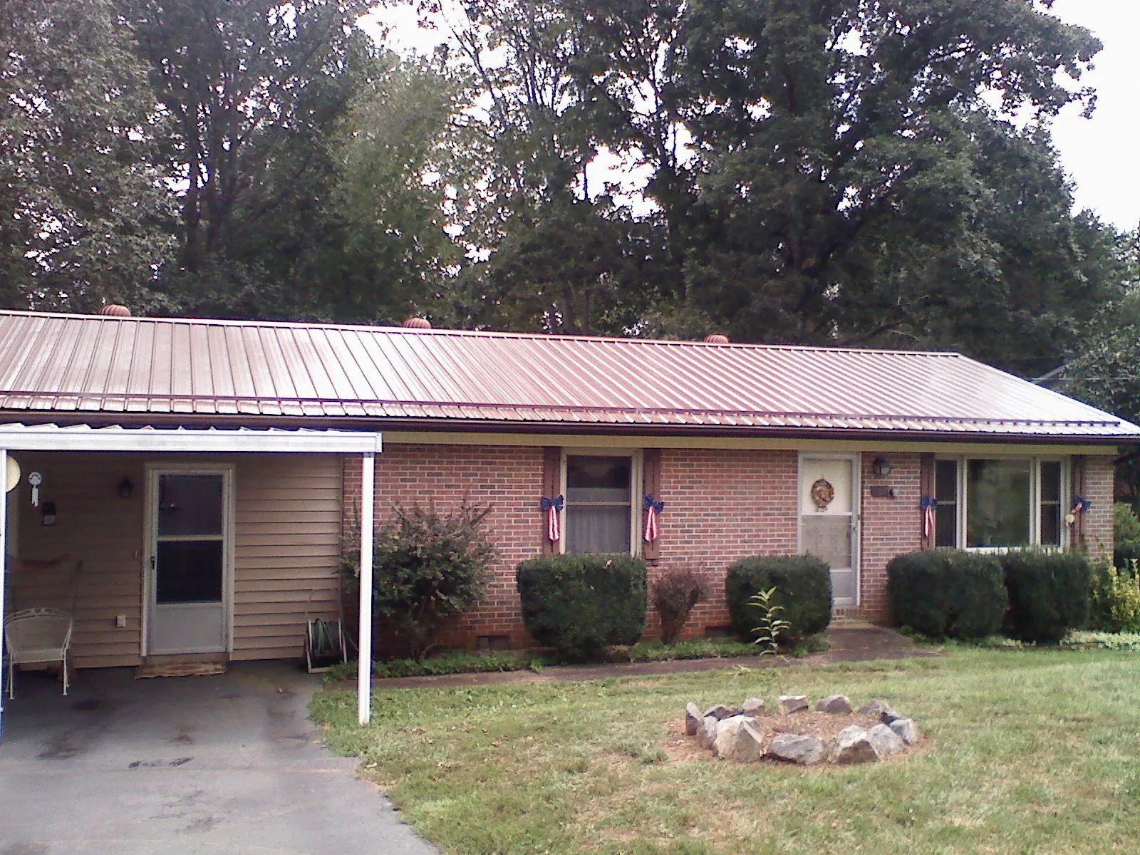 Bronze metal roof and carport on a brick ranch home — Roof Repair work by our crew in Mandan